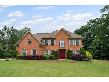 Charming two-story brick home with a well-manicured lawn and mature landscaping at 125 Ancient Oak Ln, Stockbridge, GA 30281