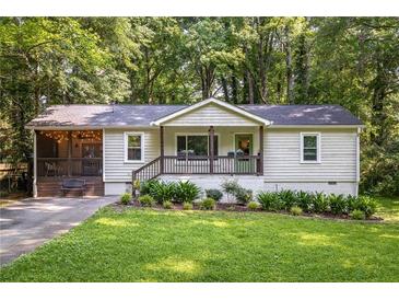 Charming single-story home features a screened porch and well-manicured lawn and landscape at 1744 Blossom Ln, Austell, GA 30168