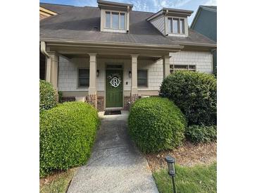 Charming home with a covered front porch, manicured landscaping, and a welcoming green front door at 2535 Village Creek Lndg, Atlanta, GA 30316