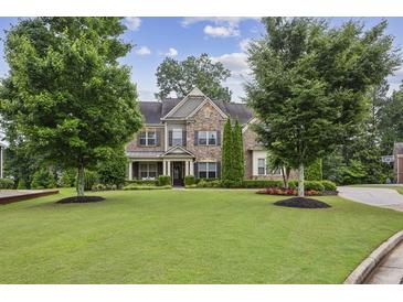 Charming two-story brick home with a well-manicured lawn, mature trees, and lovely landscaping at 2579 Lulworth Ln, Marietta, GA 30062