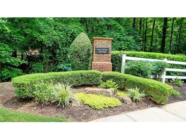 Paces Springs community entrance with brick signage, white fence and manicured landscaping at 3954 Rhyne Se Way, Smyrna, GA 30082