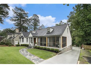 Charming home featuring a stone walkway, screened porch, and well-manicured landscaping creating an inviting curb appeal at 879 Wildwood Ne Rd, Atlanta, GA 30324