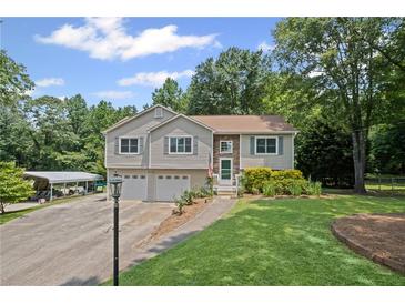 Charming home featuring a two-car garage, covered parking and a well-maintained lawn with manicured shrubbery at 208 Bruce Ct, Dallas, GA 30157