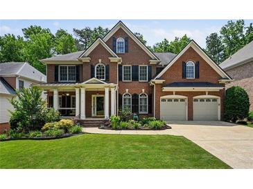 Stately brick home with well-manicured lawn, two car garage, and inviting covered front porch at 828 Ivy Ne Cv, Norcross, GA 30071