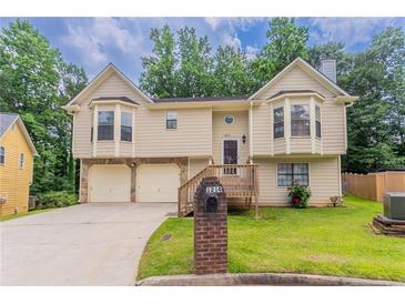 Charming two-story home with a well-maintained lawn and inviting front porch at 1214 Tyne Way, Stone Mountain, GA 30088