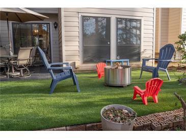 Outdoor patio with comfortable seating, artificial grass, and a fire pit, perfect for entertaining at 4846 Twin Lakes Trl, Atlanta, GA 30360