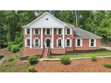 Stately brick home featuring a columned facade, manicured landscaping, and a welcoming front entrance at 5276 Beechwood Ct, Marietta, GA 30068