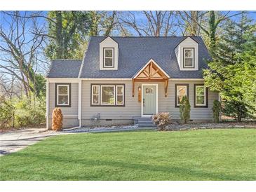 Charming home featuring a landscaped front yard and inviting light-blue front door beneath a wooden awning at 1824 Westwood Sw Ave, Atlanta, GA 30310