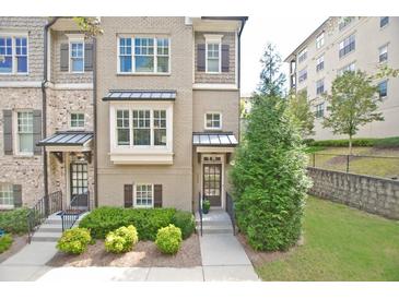 Attractive townhome featuring a well-maintained front lawn, traditional windows, and classic shutters at 4000 Chastain Preserve Ne Way, Atlanta, GA 30342