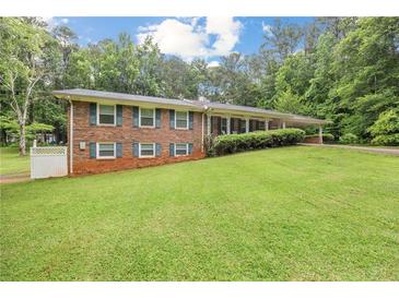 Charming brick home with well-manicured lawn, lush trees, and cozy curb appeal at 695 Hiram Sudie Rd, Dallas, GA 30157