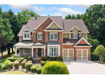 Charming two-story brick home featuring manicured landscaping and a two-car garage at 1415 Liberty Ln, Cumming, GA 30040
