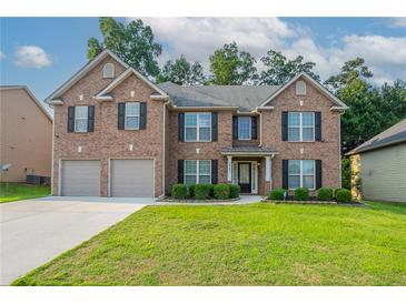 Charming two-story brick home with a well-manicured lawn and attached two-car garage in a suburban neighborhood at 2482 Brittany Park Ln, Ellenwood, GA 30294