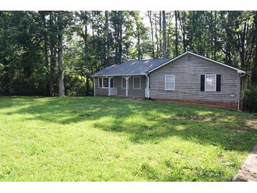 Charming single-story home with a gray exterior and a well-manicured front lawn surrounded by lush trees at 157 Sequoyah Cir, Canton, GA 30115
