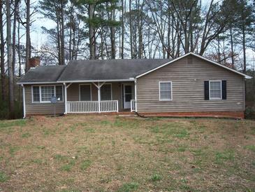 Cozy home with a welcoming front porch and mature trees in a private, wooded setting at 157 Sequoyah Cir, Canton, GA 30115