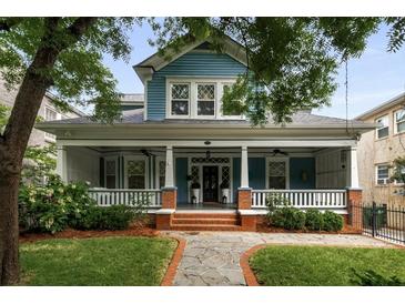 Charming two-story home featuring a spacious front porch, lush landscaping, and classic architectural details at 1038 Saint Charles Ave, Atlanta, GA 30306