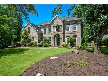Charming two-story brick home with a well-manicured lawn and lush landscaping at 2001 Mclain Nw Rd, Acworth, GA 30101