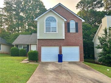 Charming two-story home with a two-car garage and well-maintained front yard in a tree-lined neighborhood at 4610 Idlewood Park, Lithonia, GA 30038