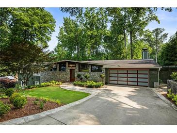 Beautiful home featuring stone accents, a modern garage door, and a professionally landscaped yard at 1164 Bonview Ne Ln, Atlanta, GA 30324