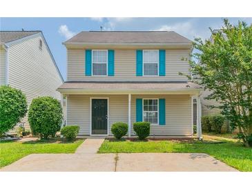 Charming two-story home featuring vinyl siding, bright blue shutters, and a well-maintained front yard at 256 Turnstone Rd, Stockbridge, GA 30281