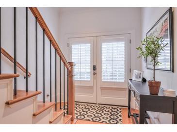 Bright foyer with staircase, console table, and beautiful double doors with modern hardware and coverings at 235 Founders Mill Ct, Roswell, GA 30075