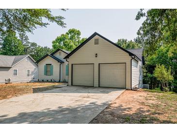 View of the home's exterior, highlighting the two-car garage and driveway at 515 Allens Landing Ct, Lawrenceville, GA 30045