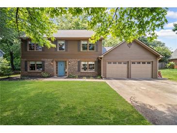 Charming two-story home with a well-manicured lawn, blue front door, and an attached two-car garage at 4967 Jett Rd, Marietta, GA 30066