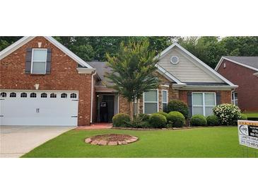 Charming single-Gathering home featuring manicured landscaping, a well-kept lawn, and a brick and stone facade at 999 Simonton Glen Dr, Lawrenceville, GA 30045