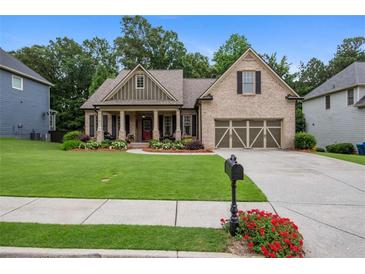 Charming single-Gathering home with a manicured lawn and inviting columned front porch at 2059 Ivey Chase Dr, Dacula, GA 30019