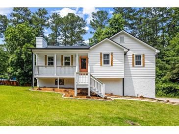 Charming renovated home with a bright exterior, inviting porch, and manicured lawn in a lush, green setting at 4430 Lamar Dr, Douglasville, GA 30134