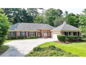 A charming single-story brick home with well-manicured landscaping, a large driveway, and a welcoming facade at 1758 N Springs Dr, Atlanta, GA 30338