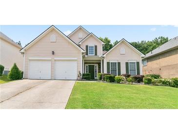 Charming two-story home featuring a well-manicured lawn and a two-car garage at 5365 Twin Creeks Dr, Norcross, GA 30071