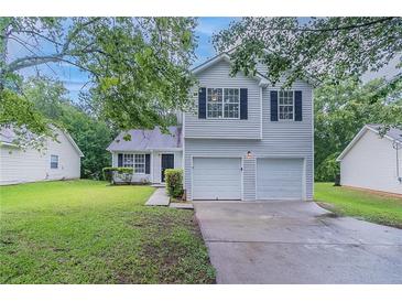 Charming two-story home with a well-maintained lawn and a two-car garage, offering curb appeal and convenience at 5421 Salem Springs Dr, Lithonia, GA 30038