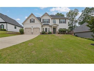 Charming two-story home with a well-manicured lawn and a two-car garage at 6135 Stillwood Ln, Cumming, GA 30041