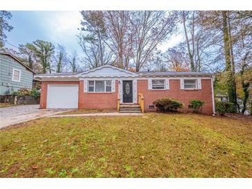 Charming brick home with a manicured lawn and a welcoming front entrance at 1410 Willow Dr, Riverdale, GA 30296