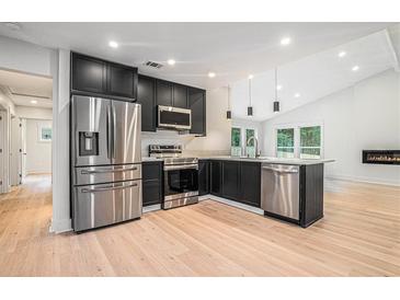 Modern kitchen features stainless steel appliances, black cabinets and an island with a sink at 3052 Brook Dr, Decatur, GA 30033