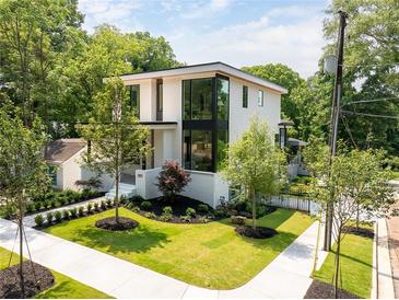 Stunning modern home showcasing a lush landscaped yard and architectural design at 3117 Robinson Ave, Scottdale, GA 30079
