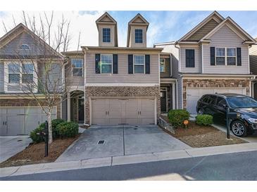 Charming townhome with neutral siding, brick accents, two-car garage, and manicured landscaping at 5008 Whiteoak Pointe Se # 15, Smyrna, GA 30080