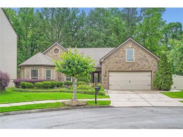Charming brick home featuring a well-manicured lawn and a two-car garage at 1873 Jameson Cir, Lawrenceville, GA 30043