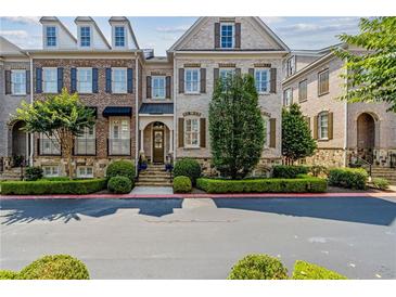 Charming townhome featuring a brick facade, manicured landscaping, and inviting curb appeal at 2362 Saint Davids Nw Sq, Kennesaw, GA 30152