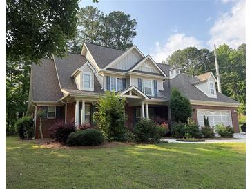 Charming two-story home with brick accents, manicured lawn, and attached garage at 2474 Starfire Ln, Loganville, GA 30052