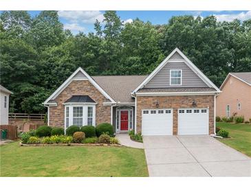 Charming single Gathering home featuring a stone facade, a bright red front door, and an attached two-car garage at 607 Little Shoals Ct, Canton, GA 30115