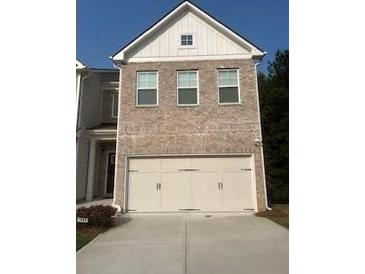 Two-story brick home with a three-car garage and a modern design at 7695 Baron Rd, Fairburn, GA 30213