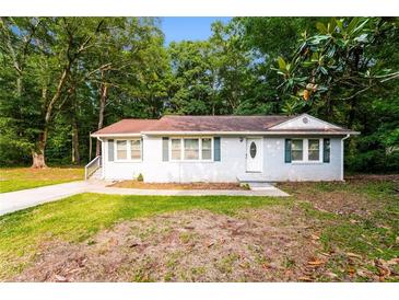 Charming one-story home with light gray brick, green shutters, and a well-manicured lawn at 10149 Puckett Sw St, Covington, GA 30014