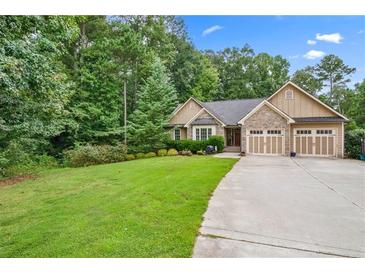 Charming home featuring stone accents, a well-manicured lawn, and an attached two-car garage at 561 Holland Rd, Dallas, GA 30157