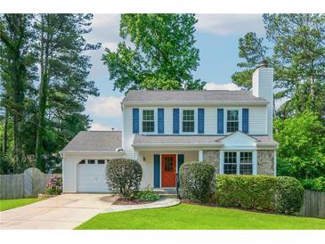 Charming two-story home featuring blue shutters, an orange door, and a well-manicured lawn at 350 Birch Rill Dr, Alpharetta, GA 30022
