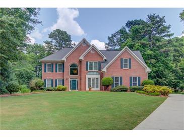 Charming two-story brick home featuring a manicured lawn and mature trees on a beautiful lot at 1721 Crowes Lake Ct, Lawrenceville, GA 30043