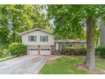Charming home featuring a 2-car garage, landscaped front yard, and a mix of vinyl siding and brick accents at 2863 Jordan Forest Trl, Lawrenceville, GA 30044