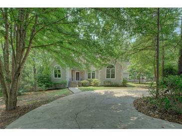 Charming home featuring a welcoming front exterior with a long driveway surrounded by mature trees at 13935 Brown Bridge Rd, Covington, GA 30016