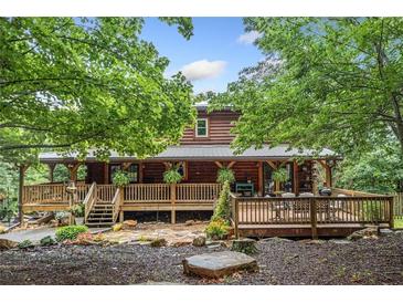 Charming log cabin with a spacious deck and beautiful landscaping nestled in a wooded setting at 521 East Valley Ne Rd, Rydal, GA 30171