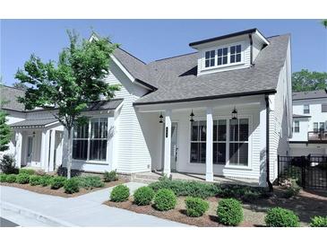 Charming two-story home featuring white siding, a covered front porch, and professionally landscaped yard at 992 Harvest Park Ln, Suwanee, GA 30024